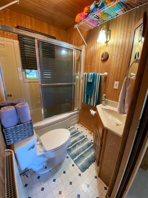 Un baño pequeño con inodoro, lavamanos y ducha.