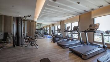 Un gimnasio moderno con cintas de correr, elípticas y equipo de levantamiento de pesas.
