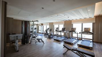 A gym with treadmills, elliptical machines, and weightlifting equipment.