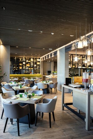 A modern restaurant with a bar area, seating arrangements, and hanging pendant lights. - Centro Mada Amman By Rotana (Amman)