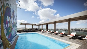 A rooftop pool with lounge chairs and a mural. - Centro Mada Amman By Rotana (Amman)