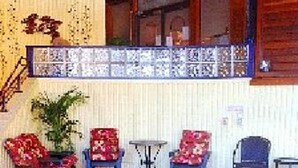 An indoor swimming pool with a tiled floor, surrounded by red floral chairs and a small table. - Vail Run Resort for Christmas Break (Vail)