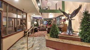 A lobby with a stone floor, a central staircase, and a large eagle statue. - Vail Run Resort for Christmas Break (Vail)