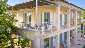 A two-story building with a balcony, outdoor seating, and a pergola. - Magnificent villa a few steps from Playa de Muro (Alcúdia)