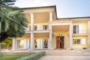 A two-story building with a central entrance, large columns, and a balcony on the upper floor.