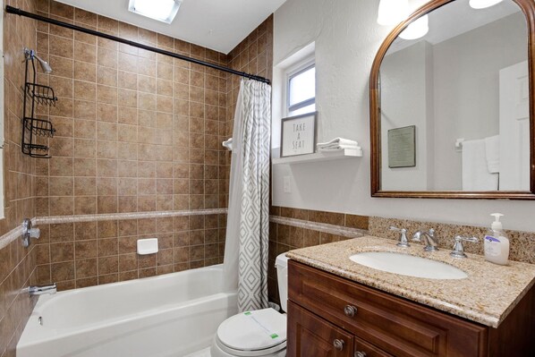 A bathroom with a bathtub, toilet, sink, and a mirror. - Amazing heated pool & spa just minutes from Anna Maria Island (Bradenton)