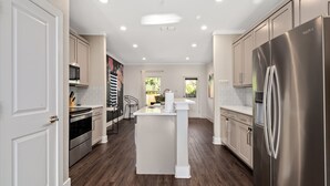 A modern kitchen with white cabinetry, stainless steel appliances, and a central island. - Luxury Comfort 5 Bedroom Home in Heart of Dallas (Dallas)
