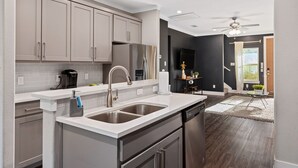 A modern kitchen with stainless steel appliances, a double sink, and a dishwasher. - Luxury Comfort 5 Bedroom Home in Heart of Dallas (Dallas)