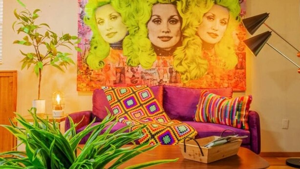 A room with a purple sofa, a colorful blanket, and a tapestry with green hair on the wall. - PSYCHEDELIC @ DOLLYS DRIVE * Wifi Grill Woods Mtns (Sevierville)
