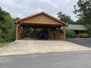 Guests can park under the covered area near the building with a green roof.