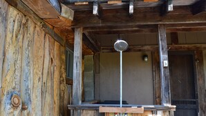 A rustic wooden cabin with a wooden porch and a metal door.