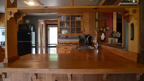 A kitchen with wooden cabinets, a built-in microwave, and a sink.