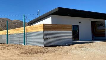 A modern building with a flat roof, a wooden section on the left, and a garage on the right.