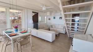 A modern living room with a dining area, a staircase, and a large window. - Sea La Vie Luxury Villa with Panoramic View and Pool (Antigua)