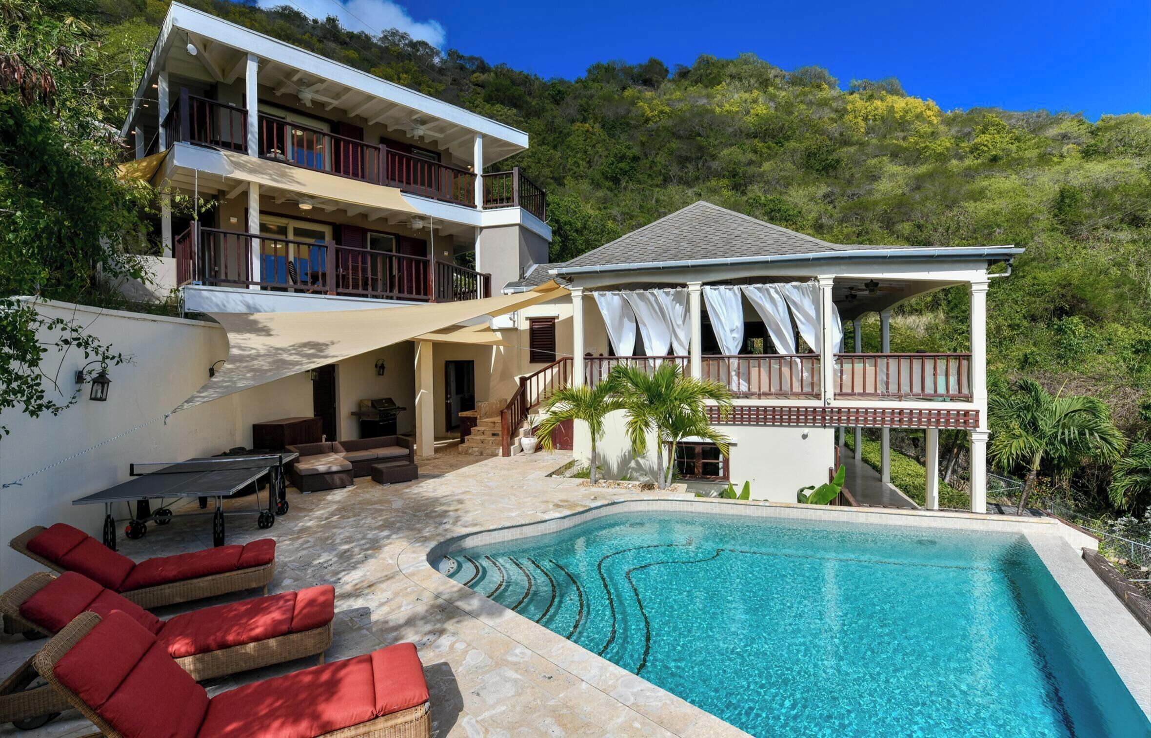 A two-story house with a swimming pool, outdoor furniture, and a covered patio.