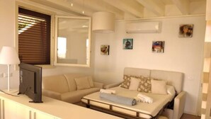 A modern bedroom with a sofa bed, a flat-screen TV, and a cabinet. - Sea La Vie Luxury Villa with Panoramic View and Pool (Antigua)