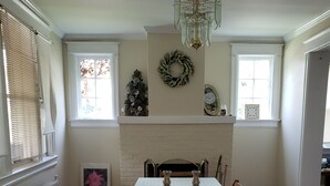 Un comedor con una mesa dispuesta para dos, chimenea y candelabro.