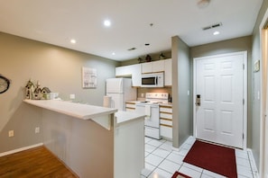 A compact kitchen with white cabinets, a microwave, and a stove.