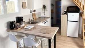 Una cocina moderna con una isla de madera, armarios blancos y un refrigerador Hisense.