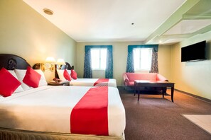 Een hotelkamer met twee bedden, een bureau, een stoel en een televisie.