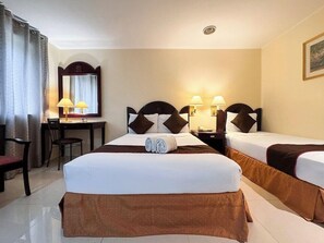 A hotel room with two beds, a desk, and a chair. - Palladium Suites (Cebu City)