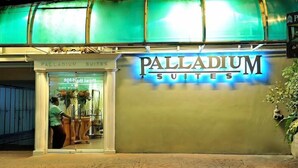Entrada de um hotel com uma placa indicando "Palladium Suites".