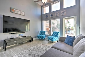 Relax in this stylish living room with a large flat-screen TV, console table, and comfortable sofa.
