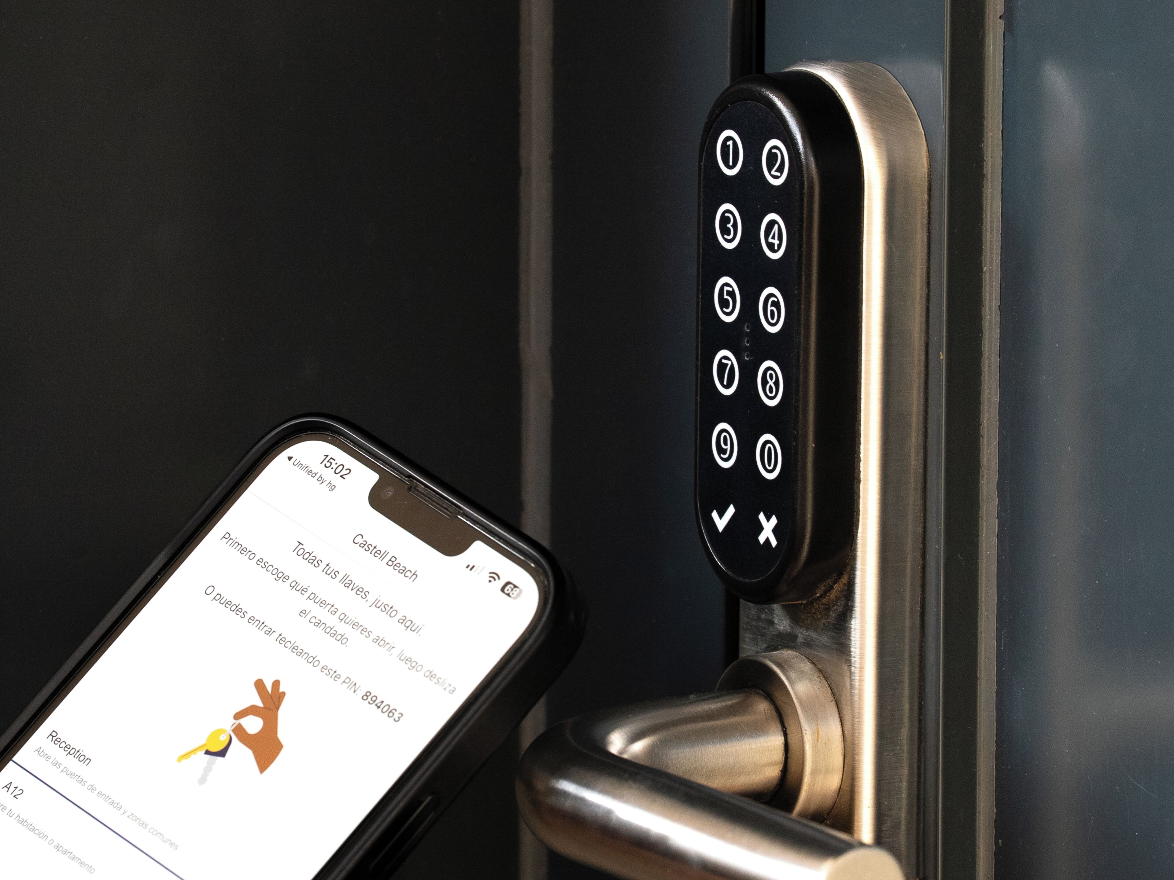 Un téléphone intelligent affichant un message sur le clavier du verrou de la porte d’une chambre d’hôtel.