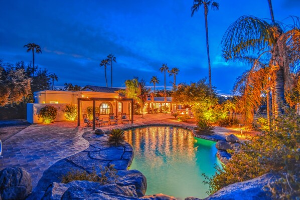 A resort with a swimming pool, palm trees, and a building with outdoor seating. - Tranquil Acre Oasis, Waterslide Heated Pool, Firepit, Spacious Backyard Estate (Scottsdale)