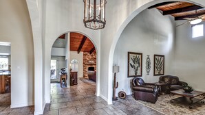 A spacious living area with a stone floor, leather furniture, and a fireplace. - Tranquil Acre Oasis, Waterslide Heated Pool, Firepit, Spacious Backyard Estate (Scottsdale)