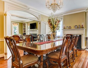 A formal dining room with a large wooden table, ornate chairs, a chandelier, and a fireplace. - Historic Charm, Prime Location Steps to River St & Parking (Savannah)