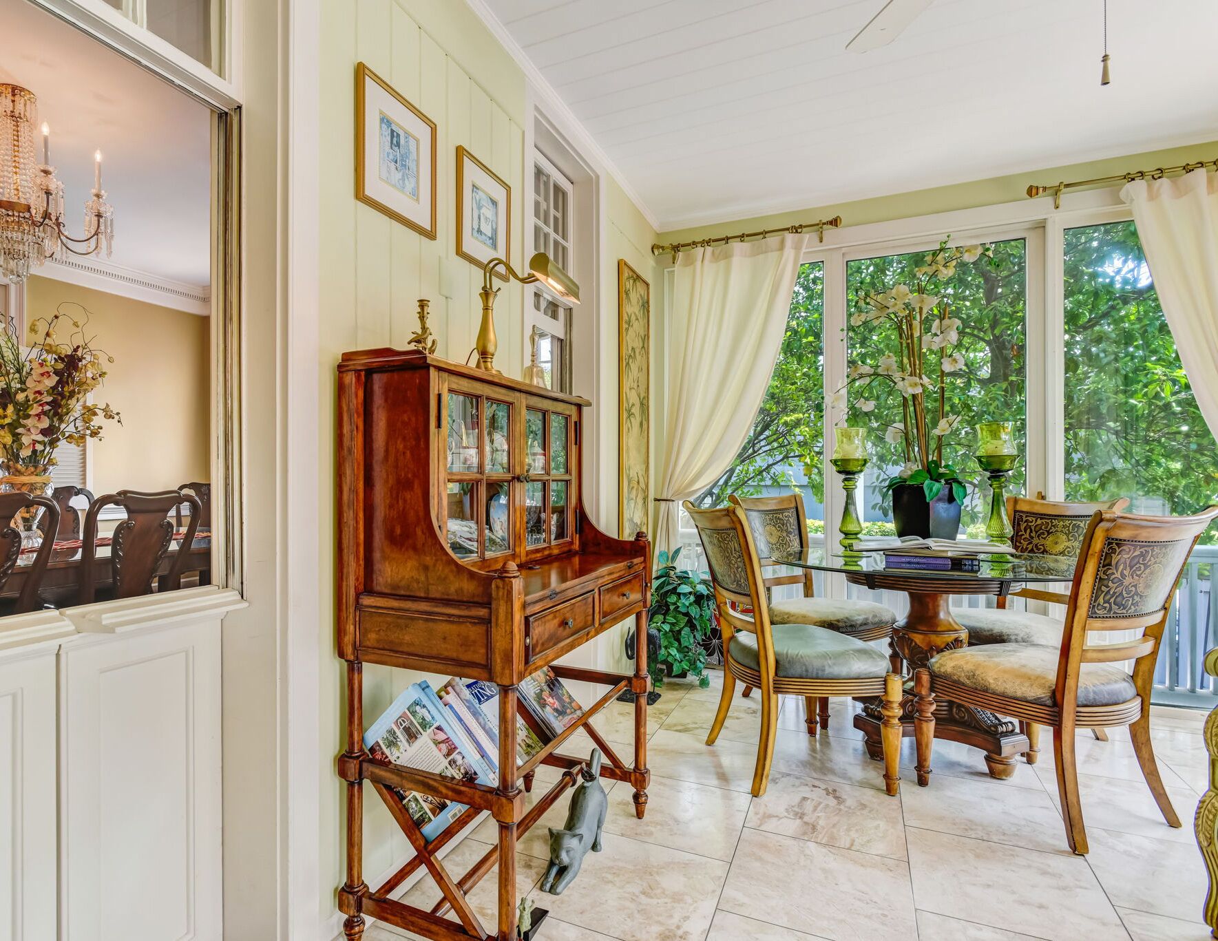 A dining area with a wooden cabinet, a chandelier, and a table set for four.