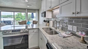 A modern kitchen with a built-in oven, stainless steel sink, and a large island with a microwave. - Balcony & Lake Access: Hot Springs Getaway! (Hot Springs)