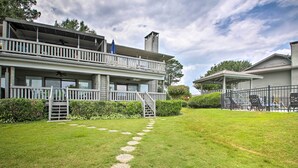 A two-story house with a covered porch, a staircase, and a well-maintained lawn with stepping stones. - Balcony & Lake Access: Hot Springs Getaway! (Hot Springs)