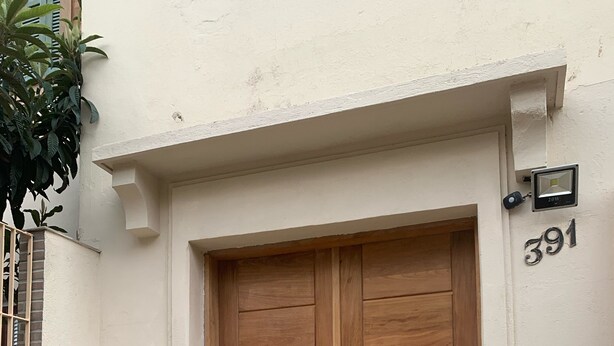 Una puerta doble de madera con unos pocos escalones de hormigón que suben hacia ella.
