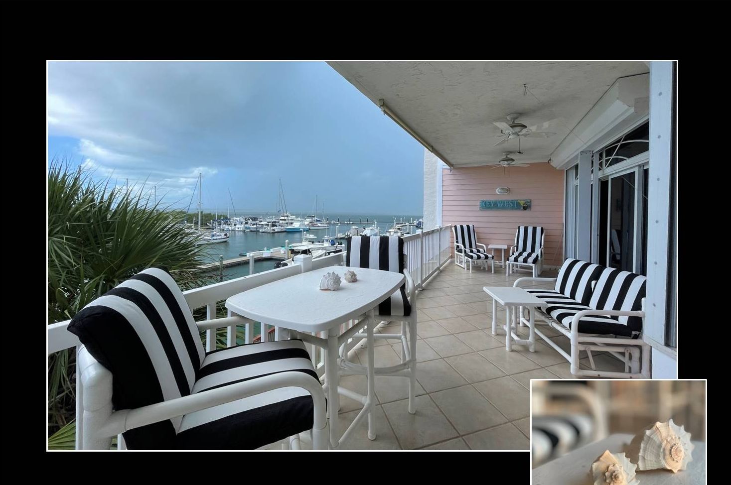 Eine Terrassen-Deck mit weißer Möbel und Blick auf den Hafen.
