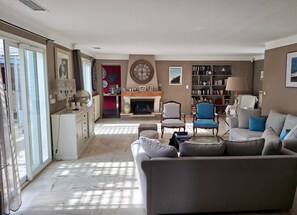 Un salon avec une cheminée, une bibliothèque et un coin repas.