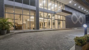 Ein modernes Gebäude mit großen Glasfenstern, einer Rezeption und einem gut beleuchteten Innenraum.