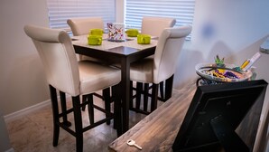 A dining area with a wooden table and four beige chairs. - Close to Attractions, Sleeps 4 (Orlando)