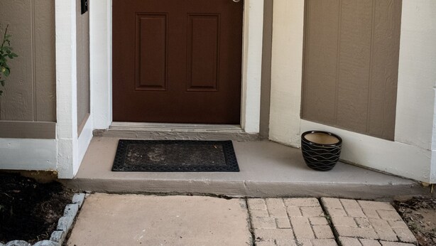 A brown front door with a light fixture above it, a doormat, and a small window to the right. - Close to Attractions, Sleeps 4 (Orlando)
