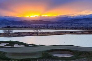 A golf course with a sunset view, a water body, and distant mountains. - Executive Edge-Master Balcony Mtn Views! (Berthoud)