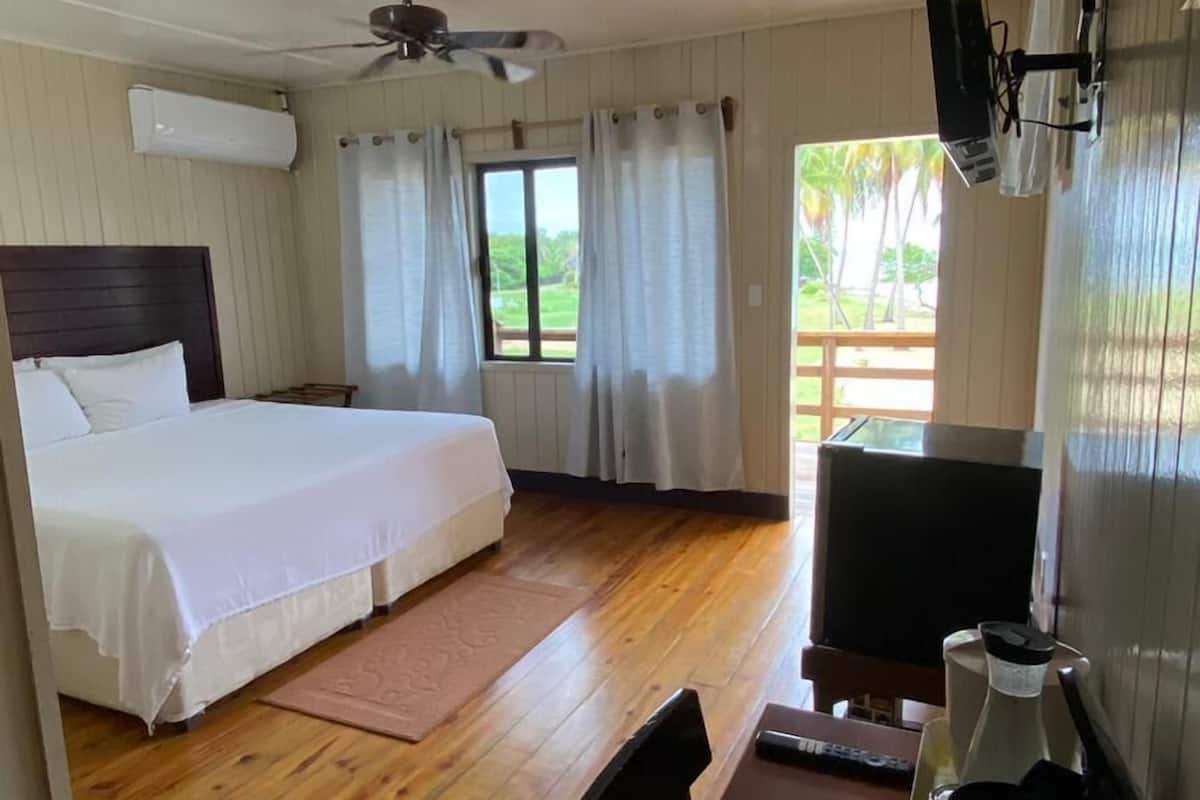 A hotel room with a bed, a desk with a chair, a coffee maker, and a TV.