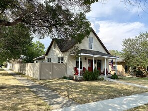 A single-story house with a front porch, a mailbox, and a small front yard.