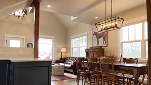 A spacious kitchen with a dining area, wooden furniture, and large windows. - G.F. Wiard House- Renovated Historic Home, Walk to Downtown Cody, Pet Friendly (Cody)