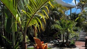 Un jardin agrémenté d’un jardinier en bois, d’un chemin de pierres et d’une pelouse.