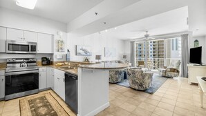 Una cocina moderna con armarios blancos, microondas integrado y una isla grande.