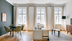 Un salon moderne comprenant un canapé, une table à manger, des chaises et un téléviseur.