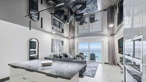 Un intérieur moderne avec un îlot central, un coin repas et un balcon offrant une vue agréable.