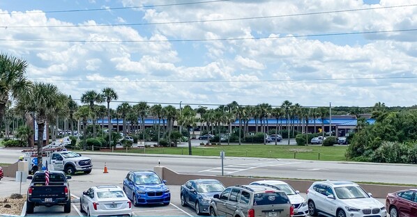 A parking lot with various cars and a building in the background.
