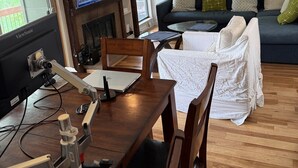 Olohuone, jossa on puinen ruokapöytä, sohva ja televisio.
